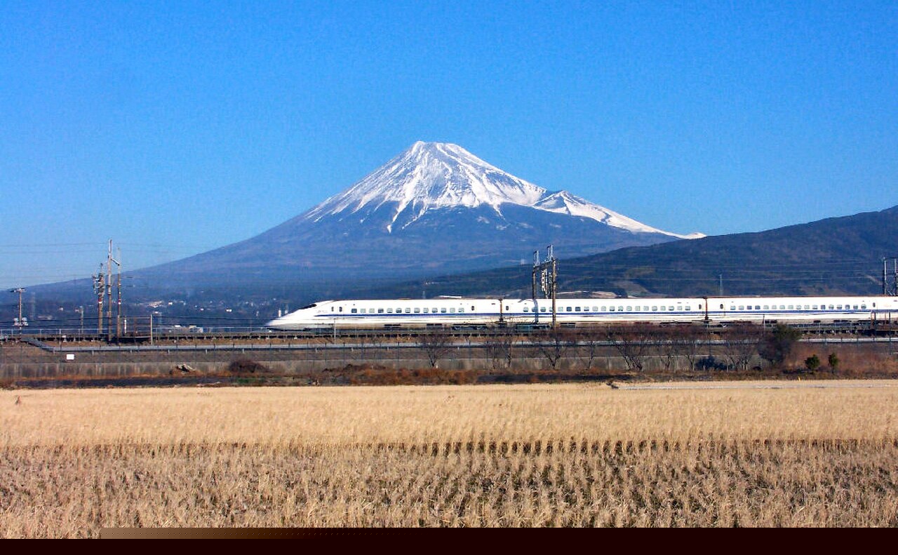 A Shinkansen bullet train passing Mount Fuji, the kind of rail travel Klook sells passes for